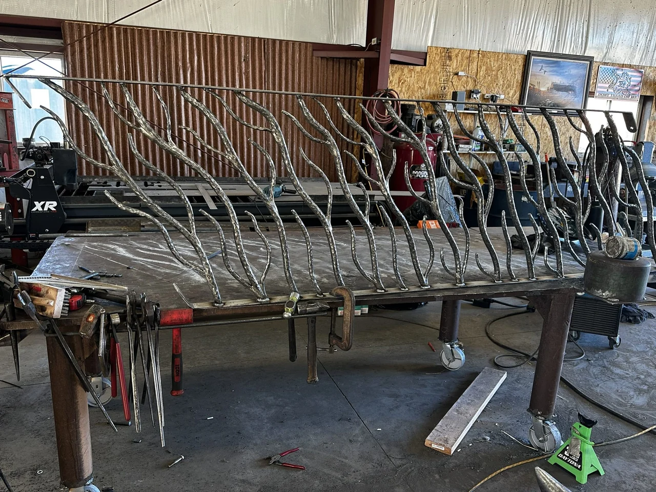 Angled forged railing section on a fabrication table in the D&S Iron Works shop