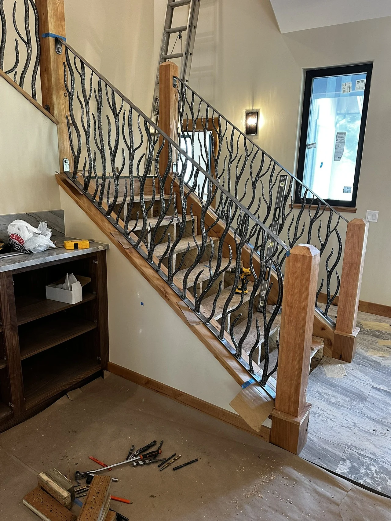 Finished interior stair railing with hand-forged steel detail